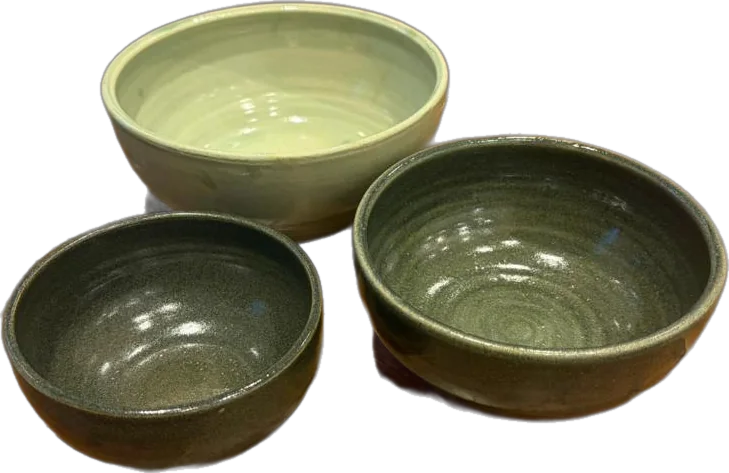 Three stoneware bowls in sage and forest green glazes