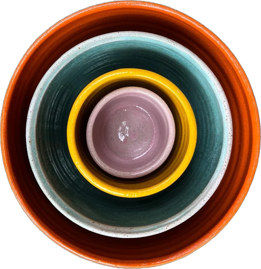 Four nesting bowls in orange, teal, yellow and pink glaze, seen from above