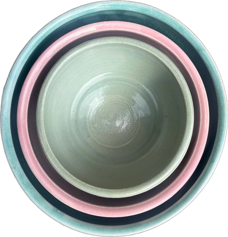 Nesting bowls in pale blue, pink and celadon green, seen from above